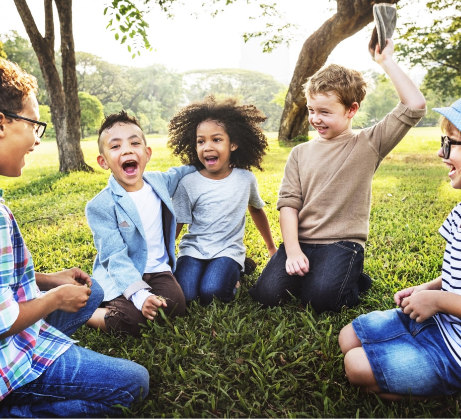 Diverse group of children laughing and playing outdoors, symbolizing community and inclusion supported by Latattore